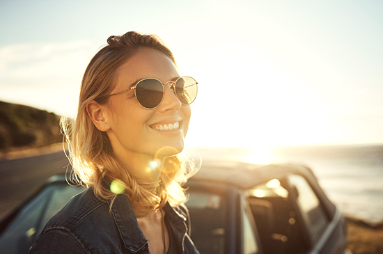 young lady enjoying road trip in the sun