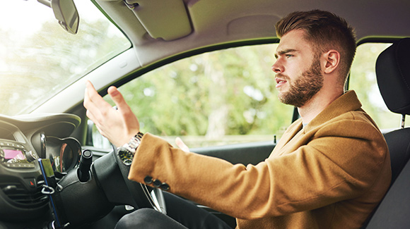 young male driver getting frustrated with another driver